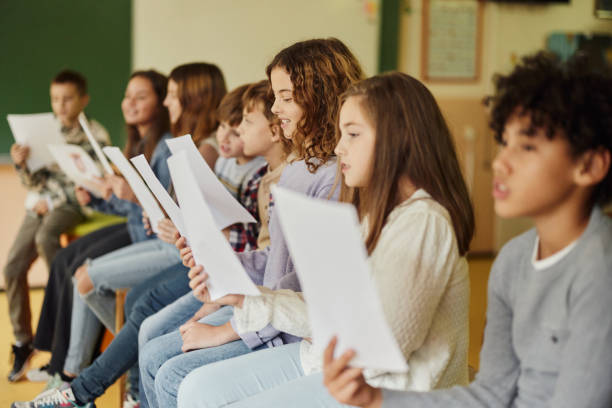 istock School kids practicing with sheet music on a class at school. 1497136735