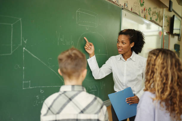 istock African American teacher explaining geometry to schoolkids during a class at elementary school. 1497136869