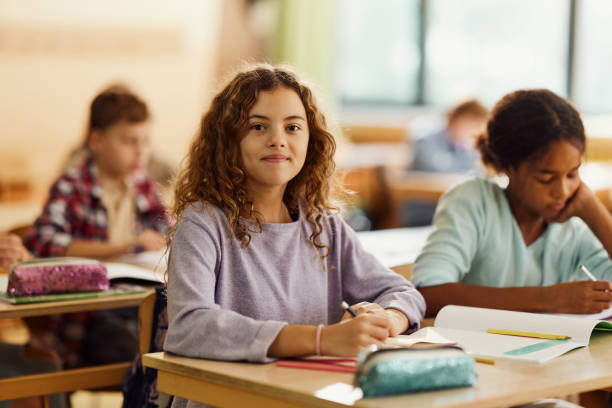 istock Smiling schoolgirl writing on a class at elementary school. 1497136959