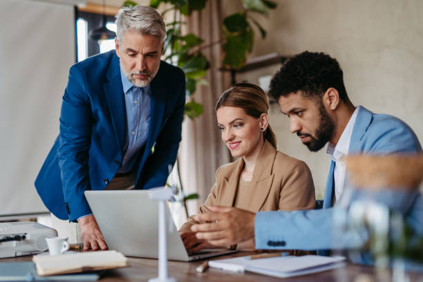 istock Young colleagues and manager discussing business operations in office. 1497137282