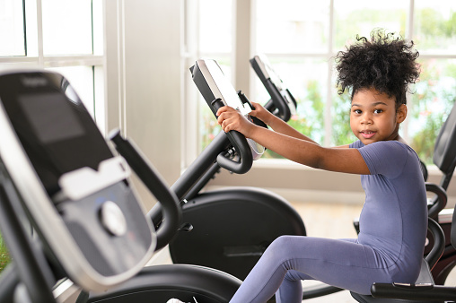 Portrait of happy African American girl in a gym. Sport, healthy lifestyle, active childhood concept. Look at camera