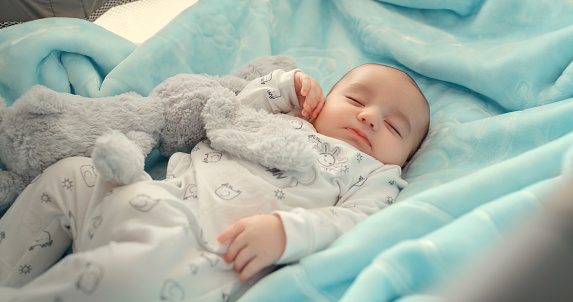 Newborn, baby and child sleeping with a teddy bear in bed for comfort, safety or security. Cute, tired and healthy infant kid dream and sleep for development, growth and childcare or peace in a house