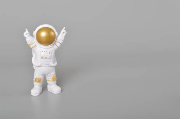 istock Astronaut toy in action isolated on a grey background. 1497139808