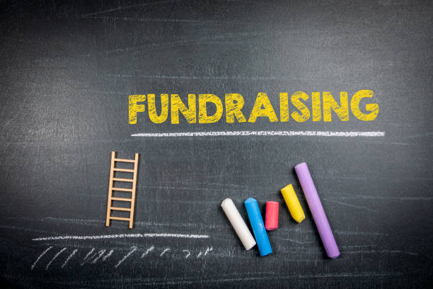 istock Fundraising Concept. Text and colored pieces of chalk on a dark board 1497140633