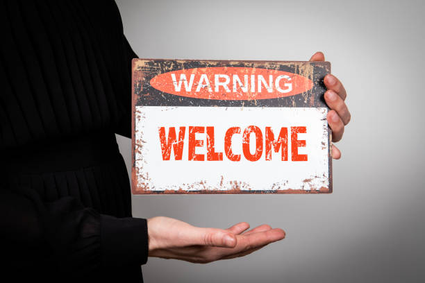 istock WELCOME. A woman is holding a warning sign with text 1497140646