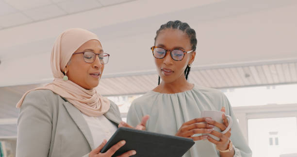 istock Tablet, advice and diversity women planning for collaboration, ideas and workflow management. Business people, muslim employee and black woman with digital technology in office 1497140898
