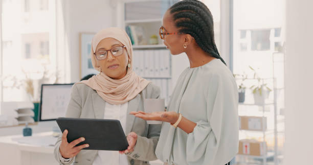 istock Tablet, advice and diversity women planning for collaboration, ideas and workflow management. Business people, muslim employee and black woman with digital technology in office 1497140932