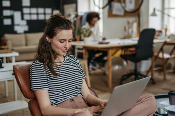 istock Young woman working on laptop in creative studio. 1497141046