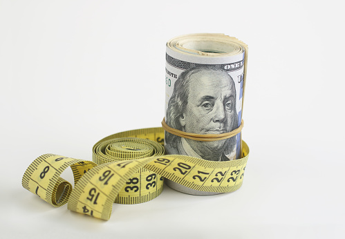Roll of US Dollars with a measure tape. Inflation rates. Price growth. Economy crisis, poverty, unemployment concept.