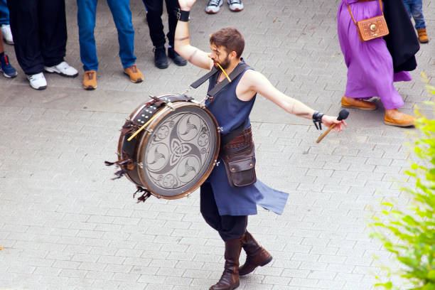 Lugo, Spain- June 12, 2022: Young drummer walking, arms outstretched. Historical clothing. Traditional festival, Arde Lucus Roman Historical Reenactment. Lugo city, Galicia, Spain.