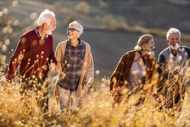 istock Happy senior couples communicating while walking up the hill in autumn day. 1497144855