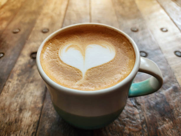 istock Heart-shaped latte art coffee in a ceramic coffee mug placed on a wooden table with copy space 1497146126