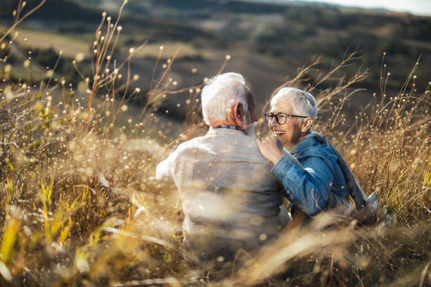 istock Relaxed senior couple talking on a hill in tall grass. 1497146206