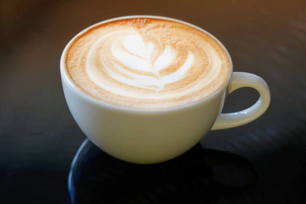 istock Latte art coffee in a white ceramic coffee mug placed on a dark table 1497146218