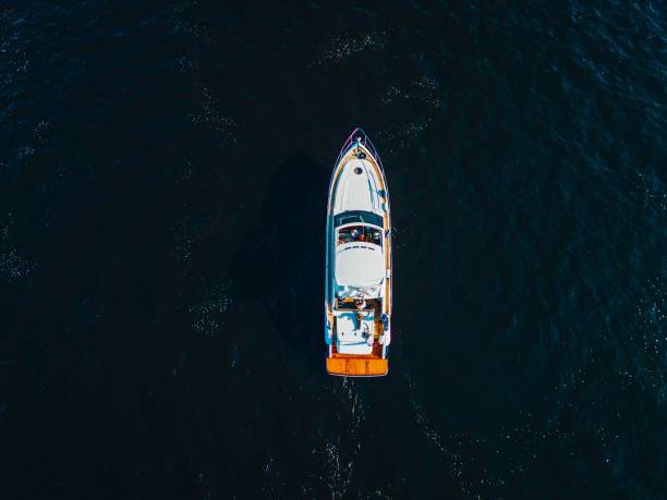 istock Small boat sailing through the tranquil waters with a bright orange life raft 1497146516