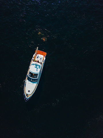An aerial view of a large white vessel sailing on the open ocean