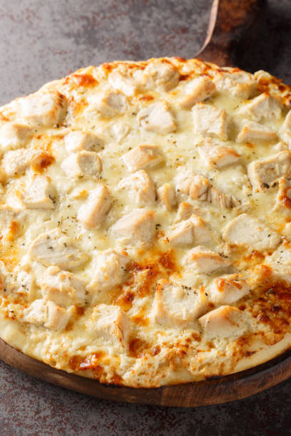 istock White Cheese Pizza with Chicken closeup on the wooden board. Vertical 1497146709