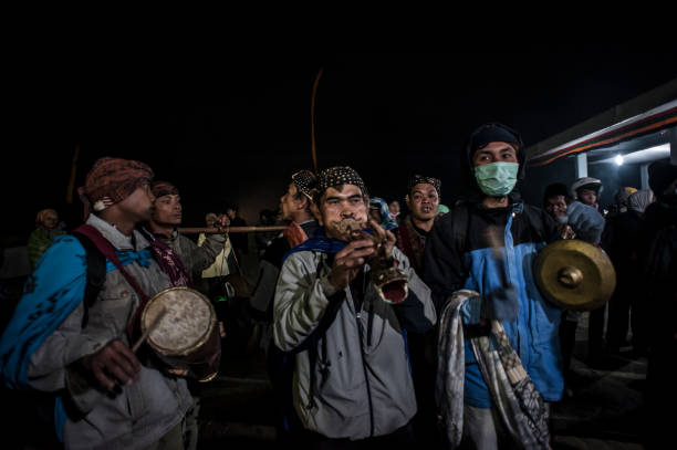 PROBOLINGGO, EAST JAVA, INDONESIA - August 11, 2014 : Tenggerese gather at crater of Mount Bromo during the Yadnya Kasada Festival on August 11, 2014 in Probolinggo, East Java, Indonesia. The Tenggerese people are a Javanese ethnic group in Eastern Java who claim to be the descendants of the Majapahit princes. The origin of the festival lies in the 15th century princess named Roro, the principality of Tengger with her husband Joko Seger, and the childless couple asked the mountain Gods to help in bearing children. The legend says the Gods granted them 24 children but on the provision that the 25th must be added to the volcano in sacrifice. The 25th child, Kesuma, was finally sacrificed in this initial after refusal, and the tradition of throwing sacrifices into the Caldera to appease the mountain Gods continues today.