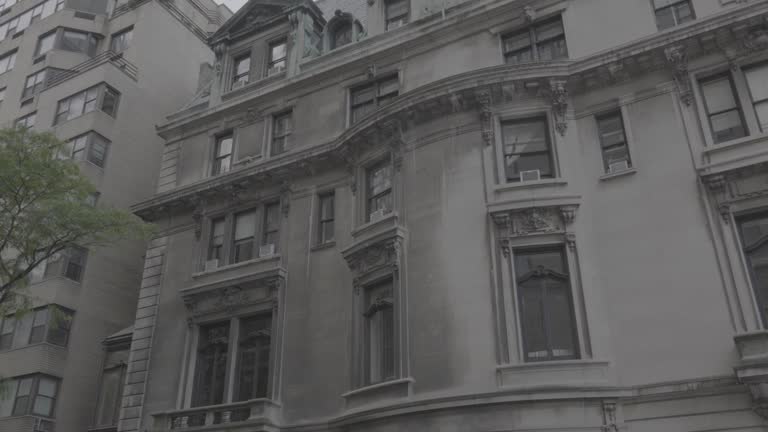 Truck from right to left across a half cleaned white gray stone rustic early century building with ornate inlays in New York city