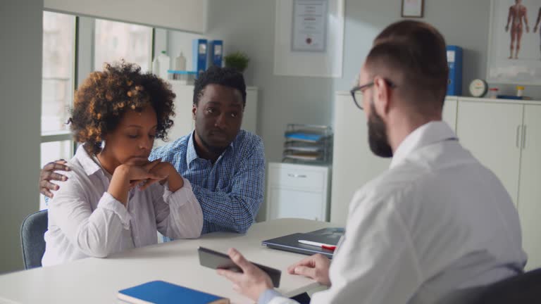 Upset african-american-american couple visiting doctor at family planning clinic