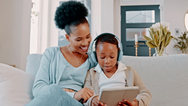 Mother, kid or laughing at tablet joke, comic meme or comedy in house, relax home or bonding living room. Smile, happy or learning child and black woman, technology or headphones for education video