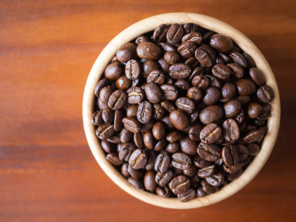 istock brown arabica coffee bean roast level medium to dark taste seed single origin caffeine espresso drink food cafe beverage Chiang Rai, Thailand coffee on wooden table background top view selected focus 1497159012