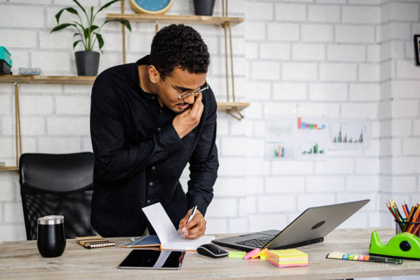 istock Man takes a notes during phone call in office 1497164314
