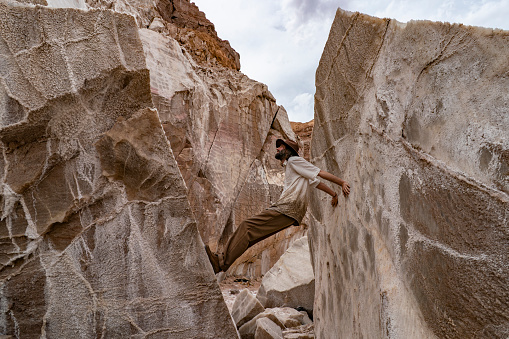 A man standing in between huge Salt Rocks in Garmsar of Iran