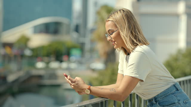 Woman in city, phone and chat with communication, social media and connectivity outdoor. Young female person, urban and smile at meme online, mobile app with technology and typing while texting