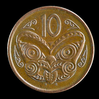 Reverse side of an old New Zealand dime with a Maori mask (koruru)