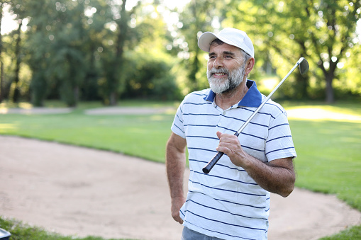 Male golf player on a golf course. About 55 years old, Caucasian man.
