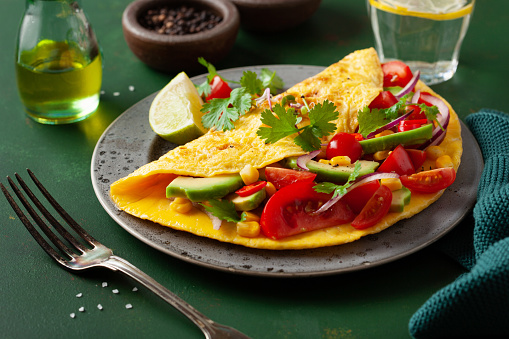 omelette with tomato, avocado onion chili and sweet corn. healthy keto diet low carb breakfast