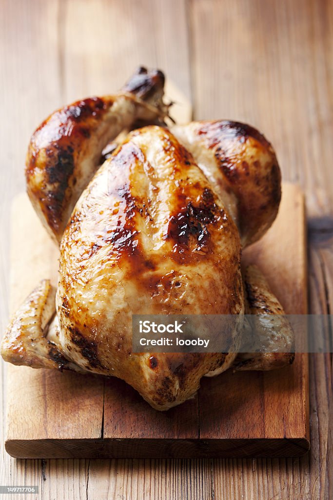 A roast chicken on a wooden kitchen board roast chicken Chicken Meat Stock Photo