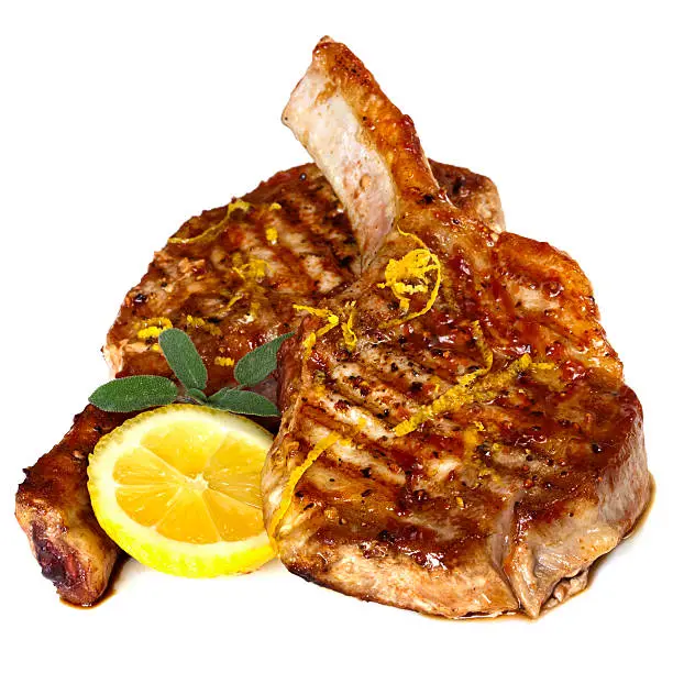 Grilled pork chops with sage and lemon, isolated on white background.
