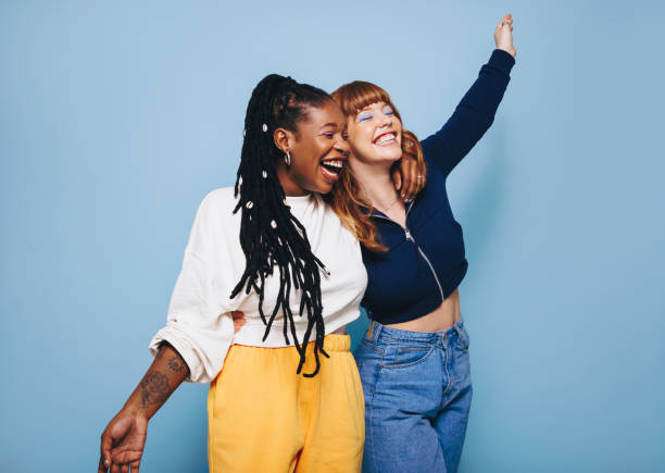 istock Two cheerful best friends laughing and having fun while embracing each other 1497178430