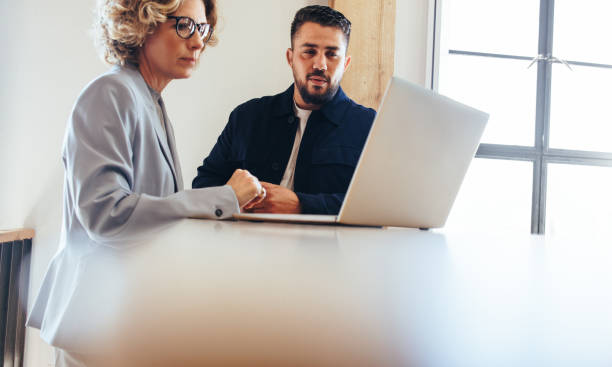 istock Business colleagues looking at a slideshow presentation on a laptop 1497180462
