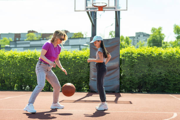 istock Mother and daughter playing basketball. 1497181776