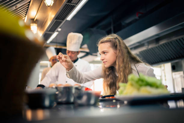 приготовление пищи под руководством опытных поваров на кухне кулинарной школы. - chef trainee cooking teenager стоковые фото и изображения