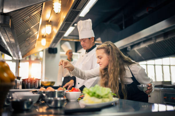 apprentice chefs are cooking in the kitchen in a cooking school. - chef trainee cooking teenager imagens e fotografias de stock