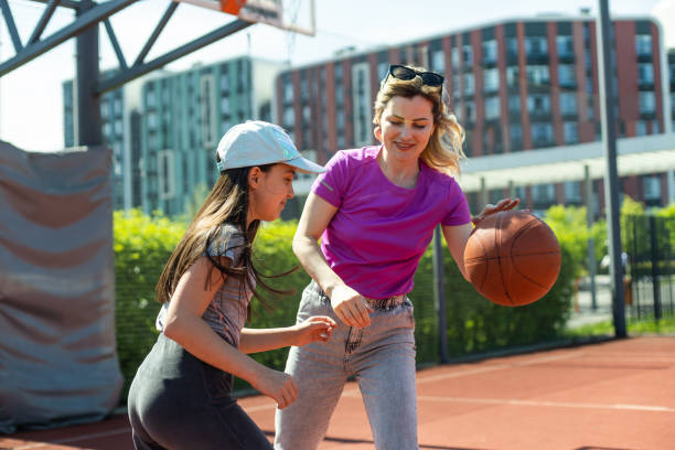istock Mother and daughter playing basketball. 1497181981