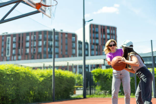 istock Mother and daughter playing basketball. 1497182117