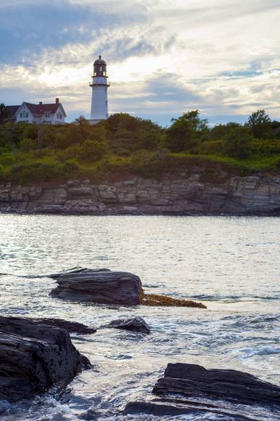 istock Lighthouse atop a jagged, rocky cliff overlooking the ocean 1497182470