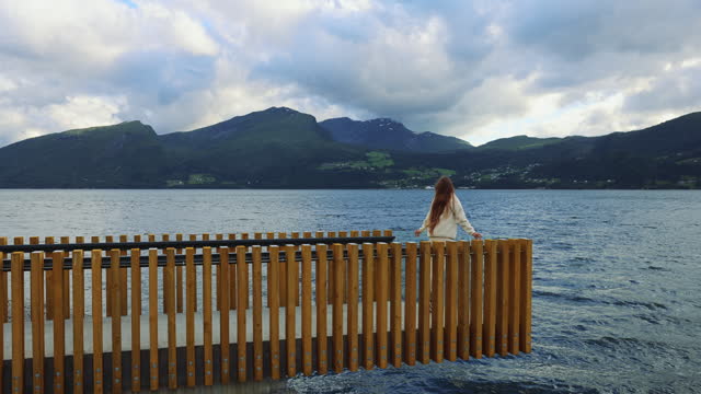 Woman Walking at City Pier Enjoying Fjord View in Norway