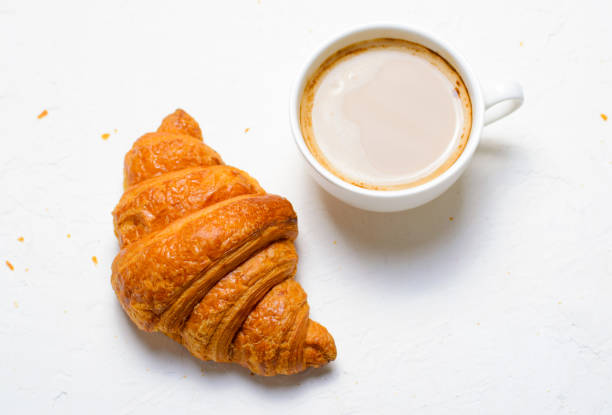 istock Croissants and Coffee Cup on White Background 1497189348