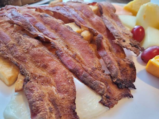 istock bacon is on a white plate with fruit and vegetables in the background 1497193789