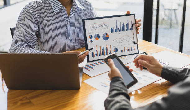 istock Financial advisor meeting discusses chart analysis in business growth reports and plans investments. 1497197649