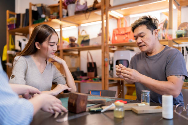 istock leather studio craftsman Asian artisan working with leather bags part while gluing piece bag handle,The process of gluing leather tanned leather craft materials by a craftsman 1497198260