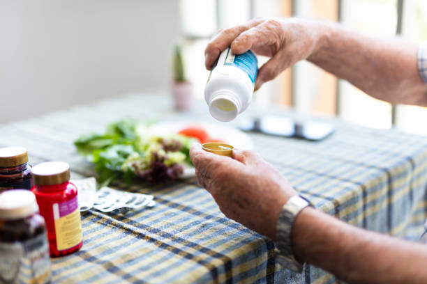 Elderly man is getting vitamin pill