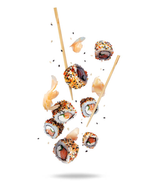 istock Delicious fresh sushi rolls with ginger in the air isolated on white background 1497206073