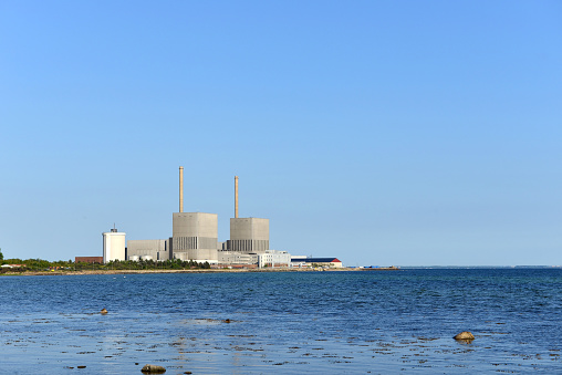 Three chimneys of nuclear power plant near the road